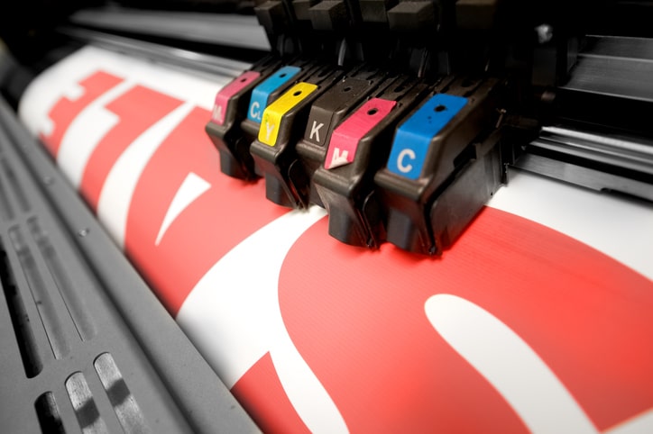 Signs - signs in one day Large format color printer printing a sale sign.